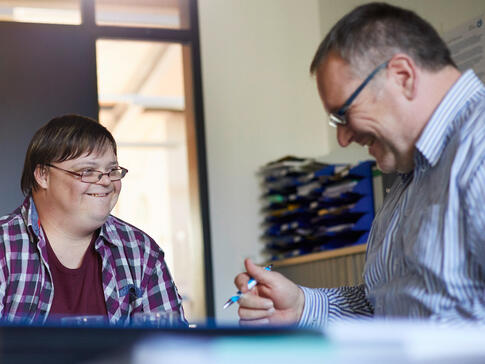 Gespräch über individuelle Unterstützung: Der Austausch zwischen Fachkräften und Menschen mit Behinderung spielt eine zentrale Rolle bei der Gestaltung inklusiver Unterstützungssysteme.